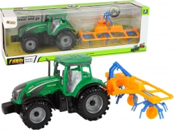Grüner Traktor mit Heuwender und Reibungsantrieb
