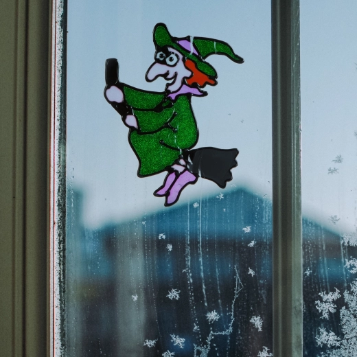 Glitzernde Halloween-Fensterdekoration als Hexe