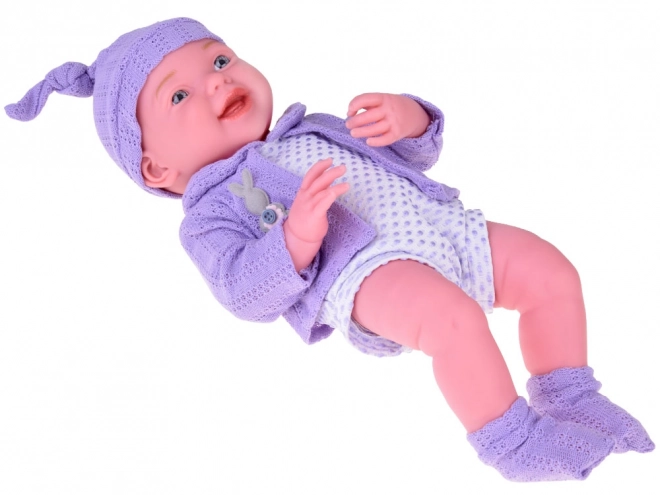 Lächelnde Babypuppe mit violettem Pullover