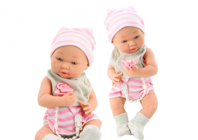 Puppenbaby im weiß-rosa Outfit mit Mütze und Zubehör