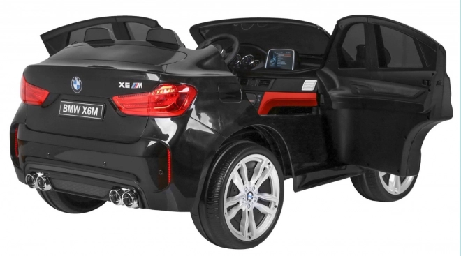 BMW X6M XXL pro 2 Kinder schwarz + Fernbedienung + Öko-Leder + Sicherheitsgurte + Langsame Anfahrt + MP3 USB + LED-Diode