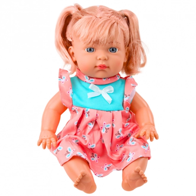 Puppenbaby im bunten Kleid mit Flasche und Geräuschen