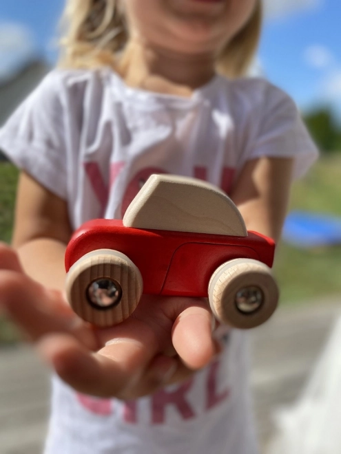 Rotes Holzauto mit Rückstoßantrieb