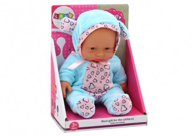 Kleine Baby-Puppe mit Schleife und blauer Mütze