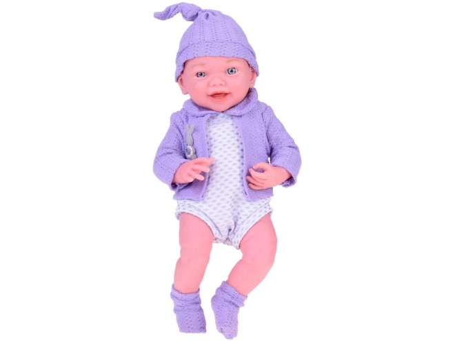 Lächelnde Babypuppe mit violettem Pullover