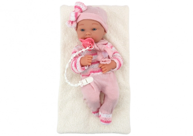 Babypuppe mit gestreiftem Pullover, Mütze und Schal in Rosa