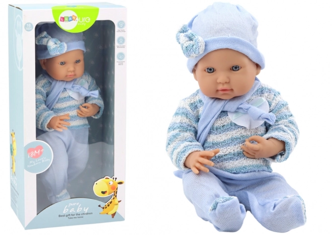 Baby Puppe mit blauem Streifenpullover, Mütze und Schal