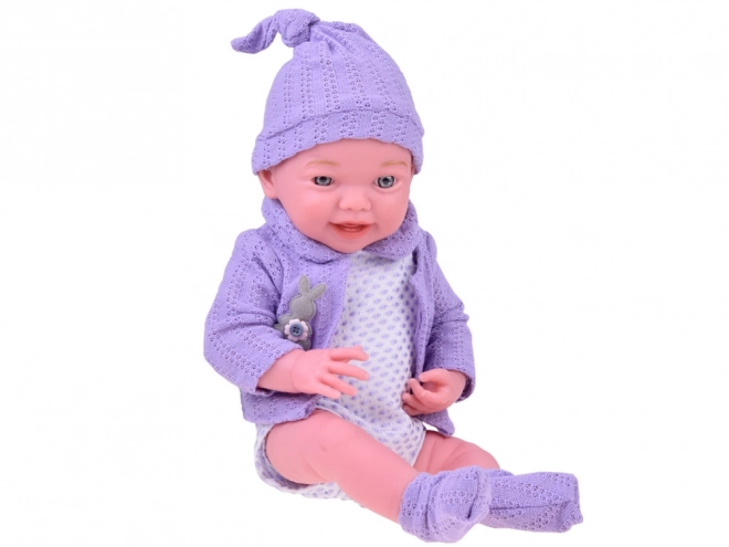 Lächelnde Babypuppe mit violettem Pullover