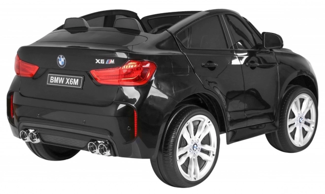 BMW X6M XXL pro 2 Kinder schwarz + Fernbedienung + Öko-Leder + Sicherheitsgurte + Langsame Anfahrt + MP3 USB + LED-Diode
