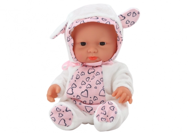 Niedliche Babypuppe mit weißem Outfit und Mütze