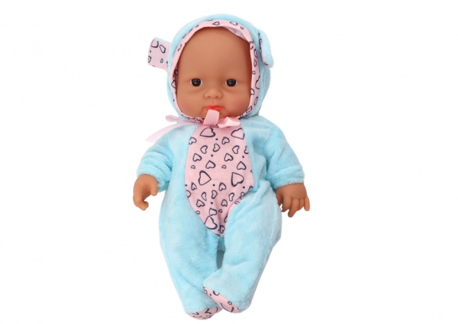 Kleine Baby-Puppe mit Schleife und blauer Mütze