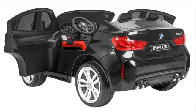 BMW X6M XXL pro 2 Kinder schwarz + Fernbedienung + Öko-Leder + Sicherheitsgurte + Langsame Anfahrt + MP3 USB + LED-Diode