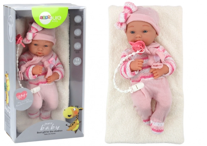 Babypuppe mit gestreiftem Pullover, Mütze und Schal in Rosa