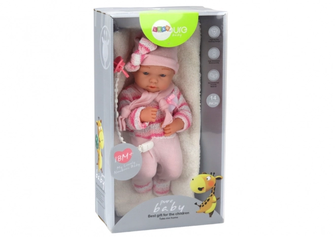 Babypuppe mit gestreiftem Pullover, Mütze und Schal in Rosa