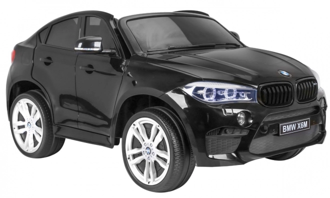 BMW X6M XXL pro 2 Kinder schwarz + Fernbedienung + Öko-Leder + Sicherheitsgurte + Langsame Anfahrt + MP3 USB + LED-Diode
