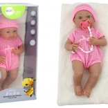 Babypuppe im rosafarbenen Outfit mit Mütze, Schnuller und Decke