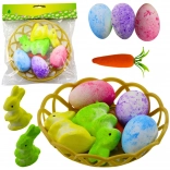 Osterdekoration mit Körbchen mit Hasen, Eiern und Karotten